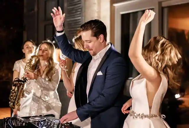 DJ Chris Force am DJ-Controller neben einer Live-Saxofonistin und feiernden Hochzeitsgästen in Frankfurt am Main